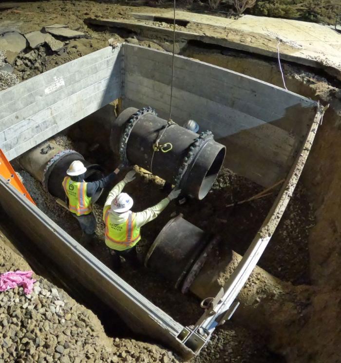 Crews lower new pipe into ground
