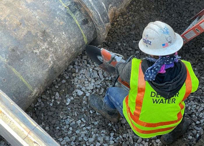 Construction worker cuts through pipe