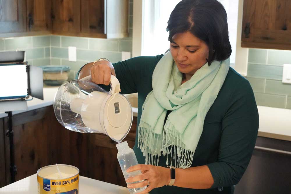 Woman uses water pitcher with filter certified to remove lead