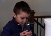 Child drinks a glass of water