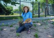 Denver Water employee poses with plant outside of Einfeldt facility. 
