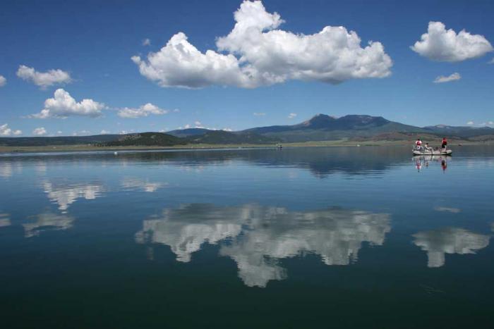 Clouds reflected on the flat surface of the water at a reservoir.