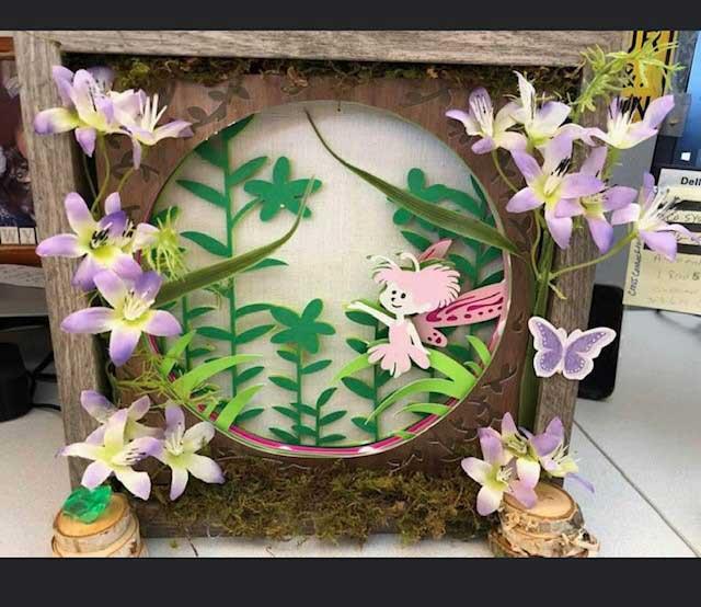 A three-dimensional shadowbox with paper flowers, ferns and fairies.