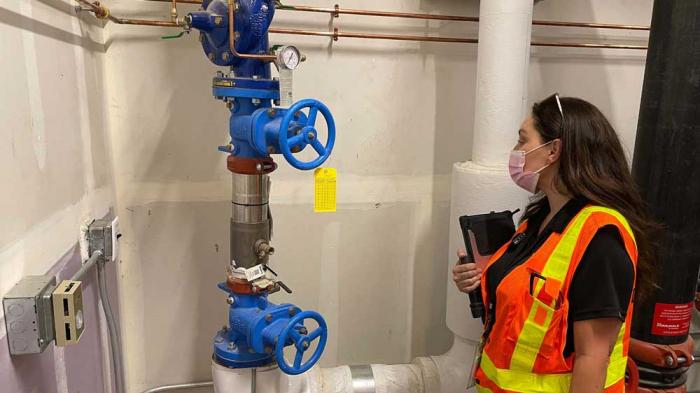 Employee inspects a warehouse backflow prevention device