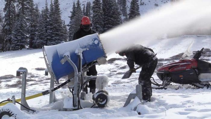 Snowmaking machine blows snow on the slopes