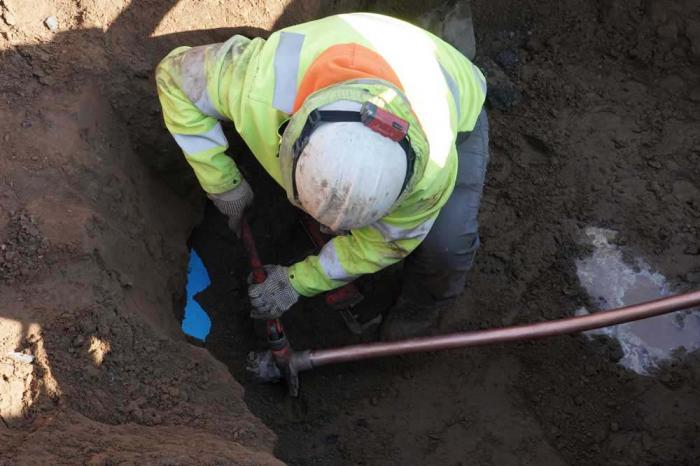 Worker replaces lead pipe