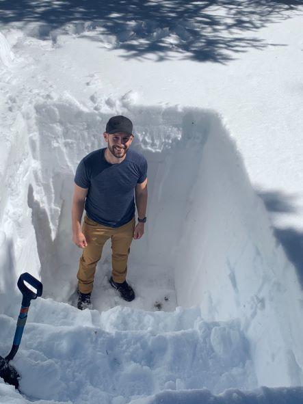 Man standing in snow pit