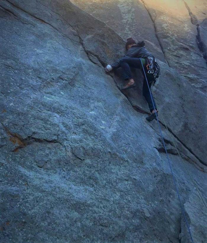 Man climbs steep rock face