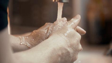 Washing of hands under faucet of running water.