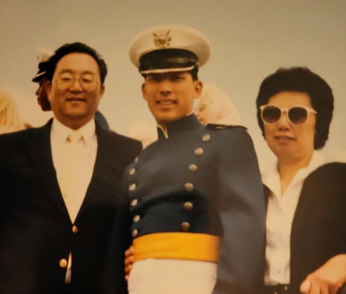 Man in uniform stands between parents