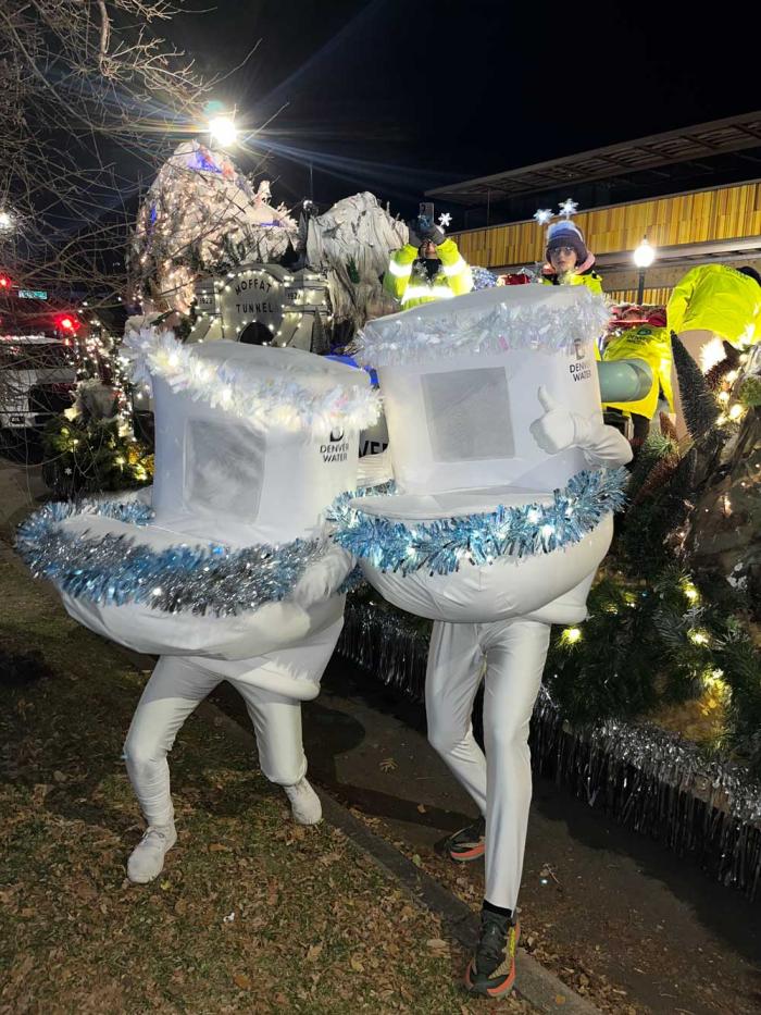 Two people in toilet costumes festooned with tinsel and lights 