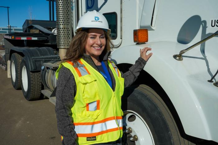 Woman stands near a Denver Water truck