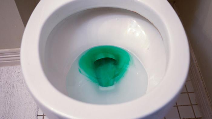 Toilet bowl with the water colored with food coloring.