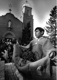 Young boy sits outside of a church