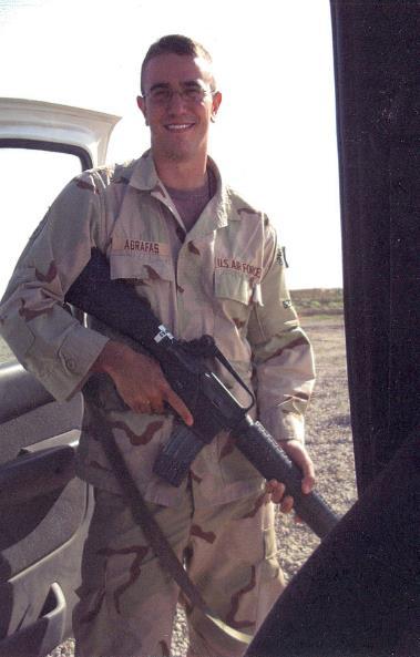 A soldier stands near vehicle door.
