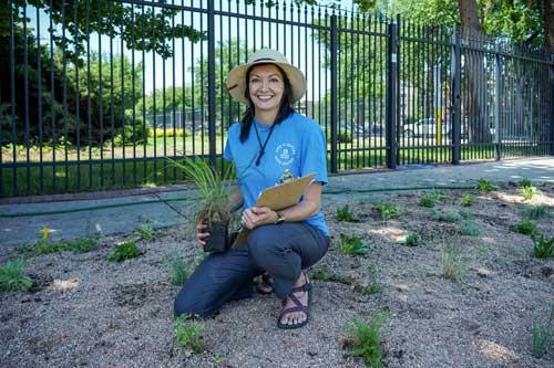 Denver Water employee poses with plant outside of Einfeldt facility.