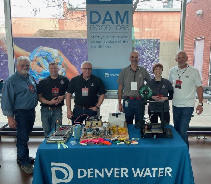 A group of Denver Water IT employees stand at a table