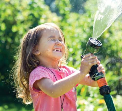 Girl playing with a water hose. 