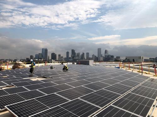 Crews install solar panels on top of Denver Water's admininstration building in 2019