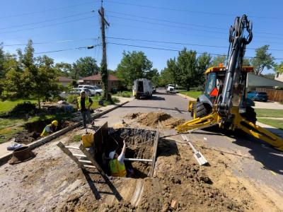 Crews dig up pipe in a street