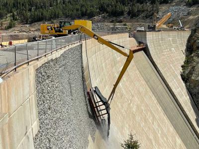 Heavy equipment roughens the face of the dam
