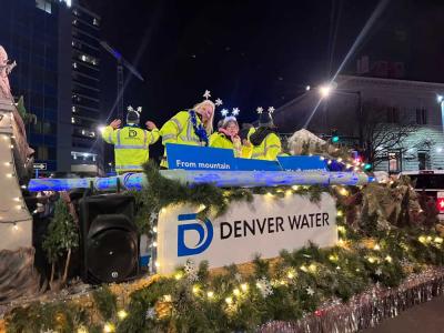 Parade float filled with people and lights saying "From Mountain to TAP"