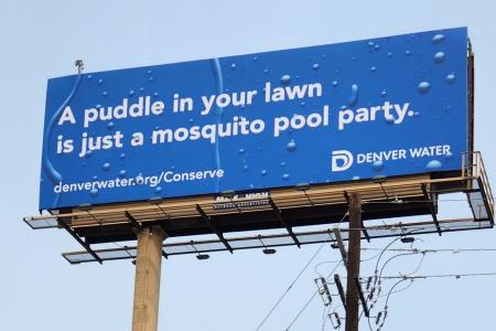 A billboard that reads "A puddle in your lawn is just a mosquito party." 