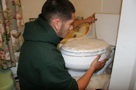 A member of the Mile High Youth Corp installs a toilet for Denver Water. Many new, ultra-high efficiency toilets are eligible for rebates from Denver Water.