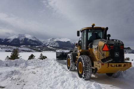 A frozen Lake Dillon is shown in the background as a Denver Water snow plow removes snow around the reservoir.