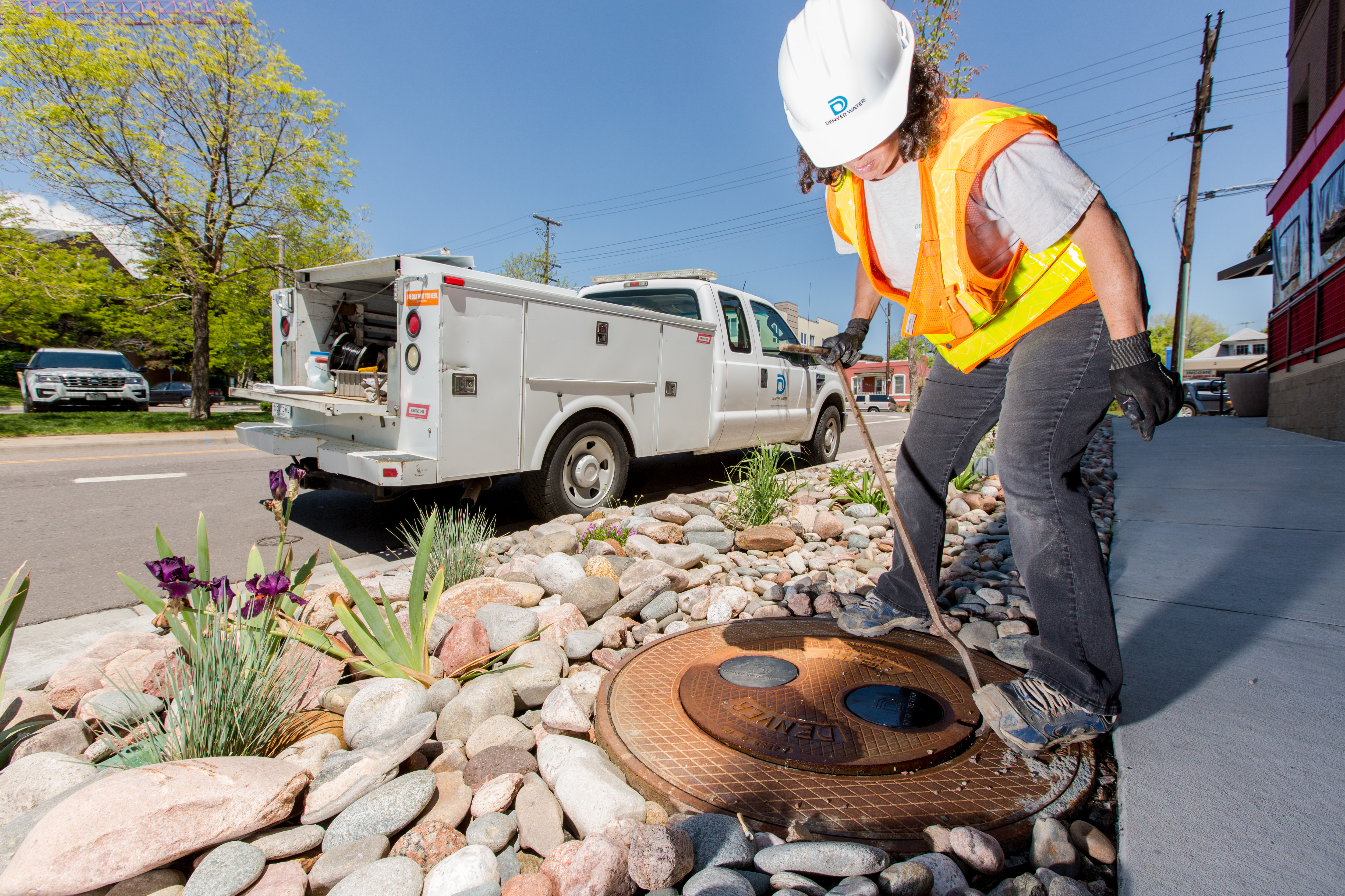 Kesha Coombs, Denver Water meter inspector, opens a manhole cover to access a meter pit.