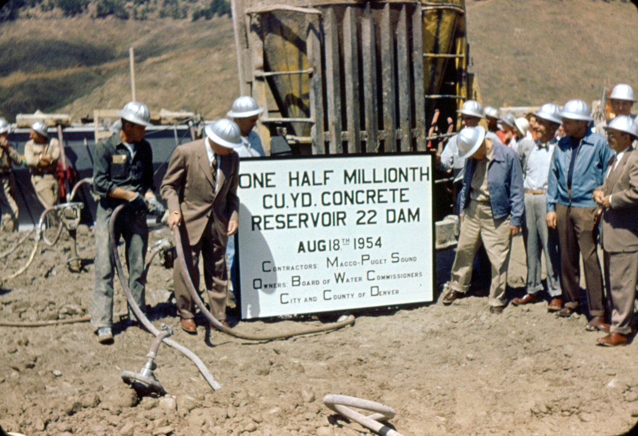 This picture shows people holding up a sign at the Gross Dam construction site.