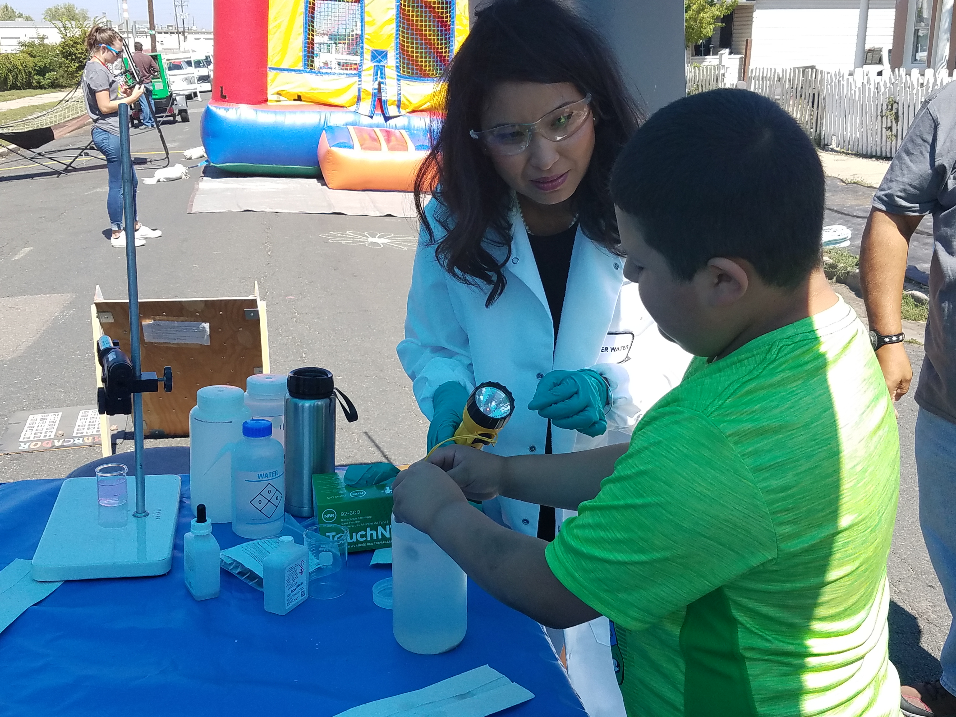 Selene Hernandez-Ruiz, water quality lab manager for Denver Water, talks about water quality with children at the GrowHaus' 6th Annual Block Party on Sept. 8, 2018.