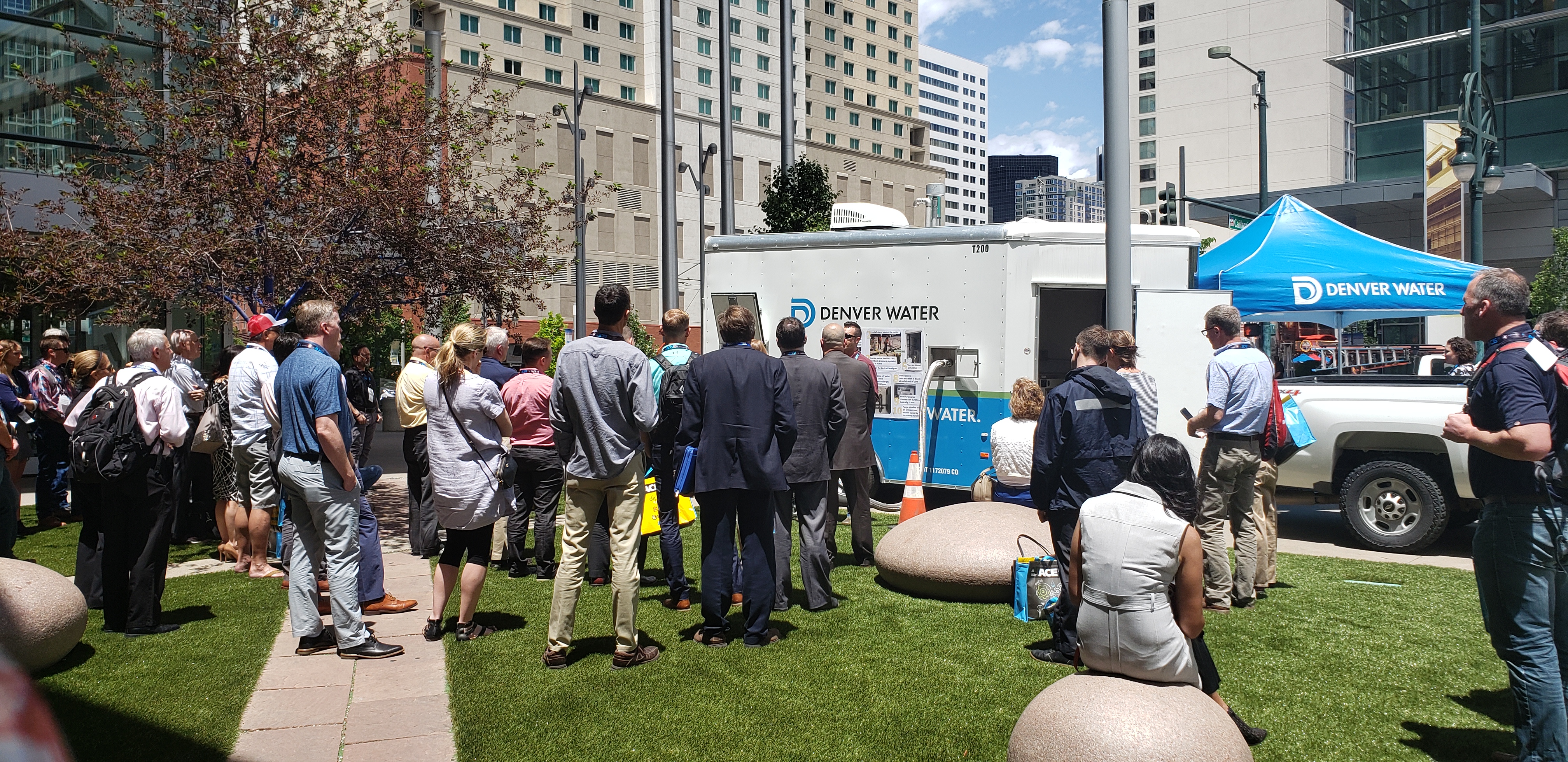 A Denver Water trailer and tend is surrounded by a crowd.