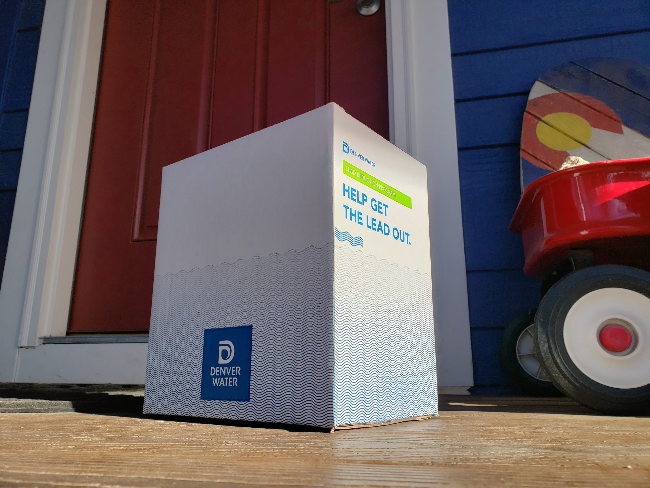 A box on a porch from Denver Water that read "Help get the lead out."