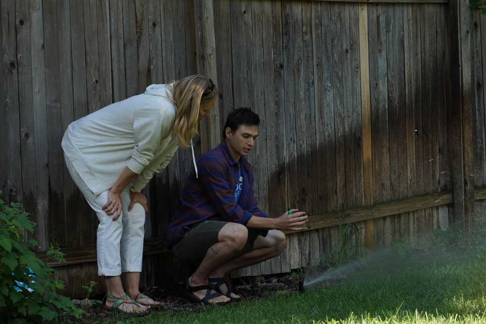 This picture shows a homeonwer in her backyard with an irrigation specialist. Photo credit: Denver Water.