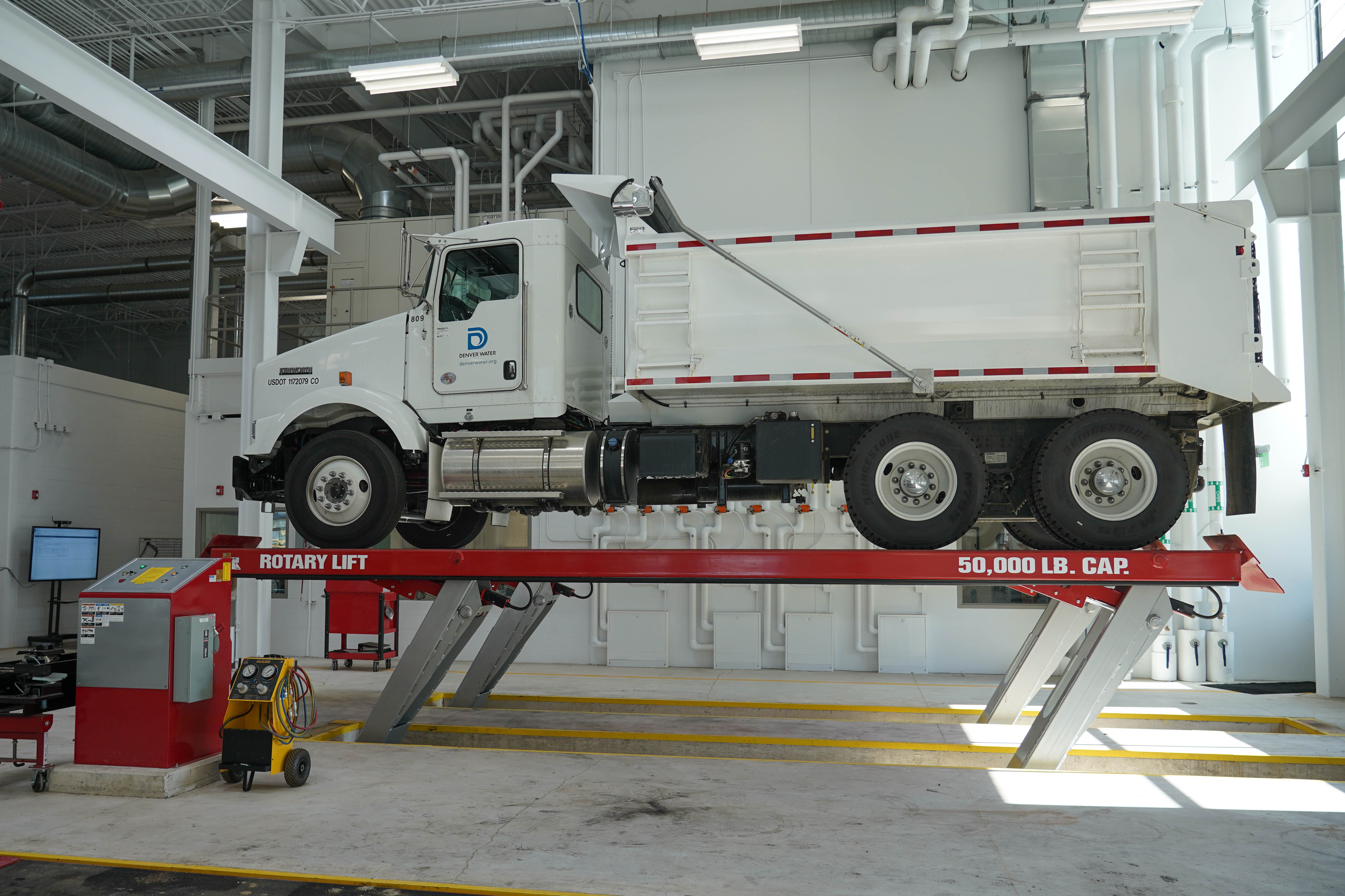 This photo shows a dump truck up on a lift.