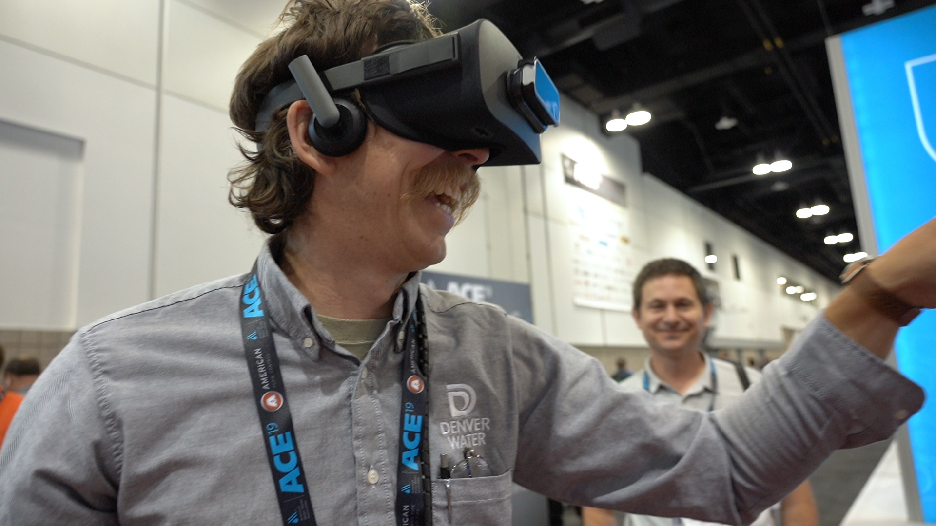 This picture shows a Denver Water employee with virtual reality goggles on playing at an interactive exhibit.