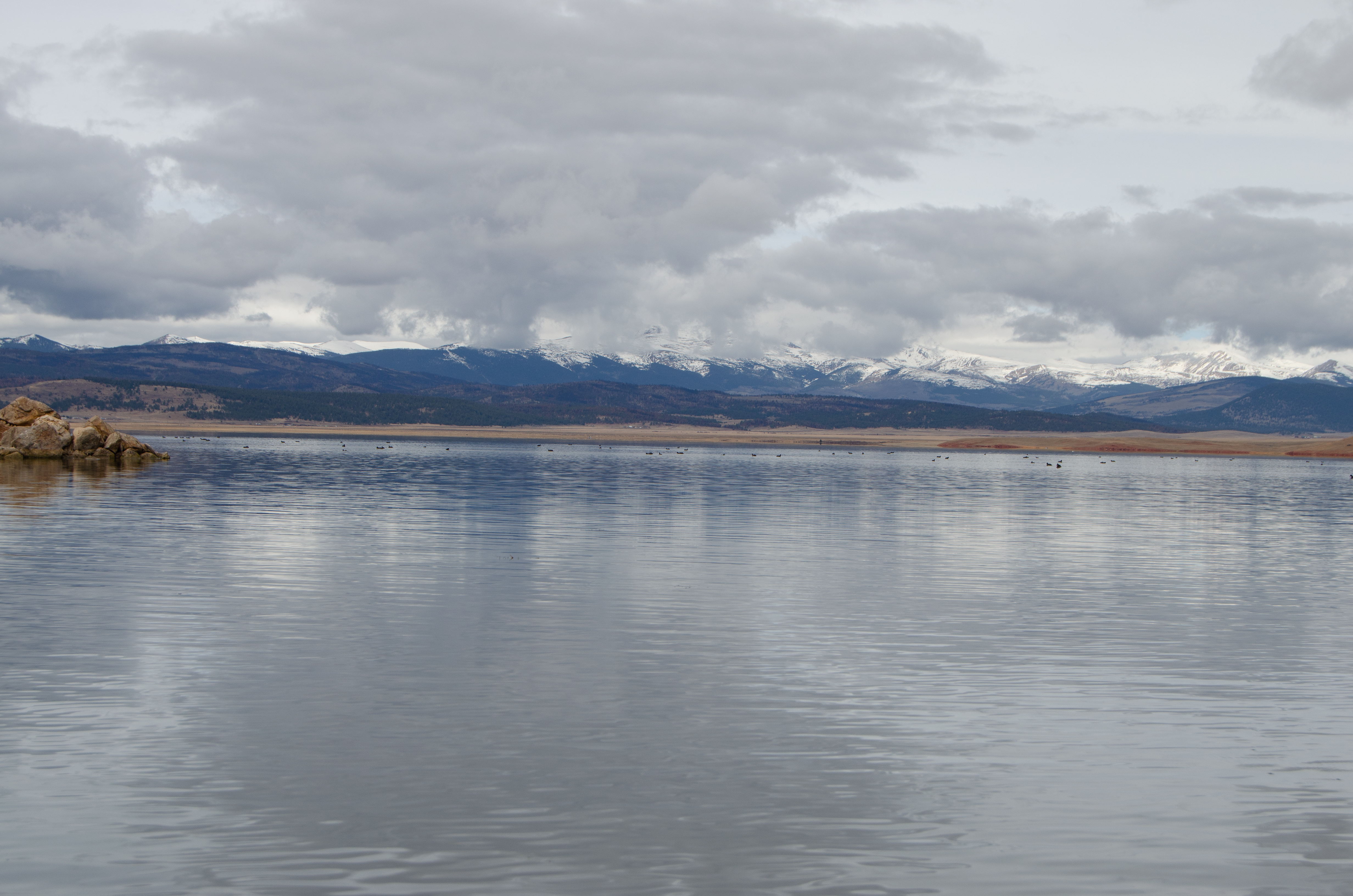 Water pools in the foreground with snow-capped peaks in the distance.