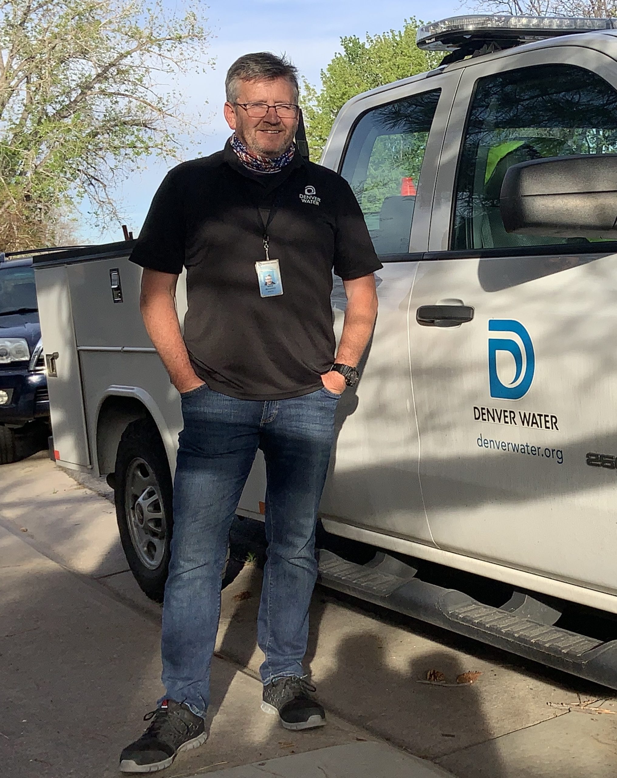 A man stands next to a Denver Water service vehicle.