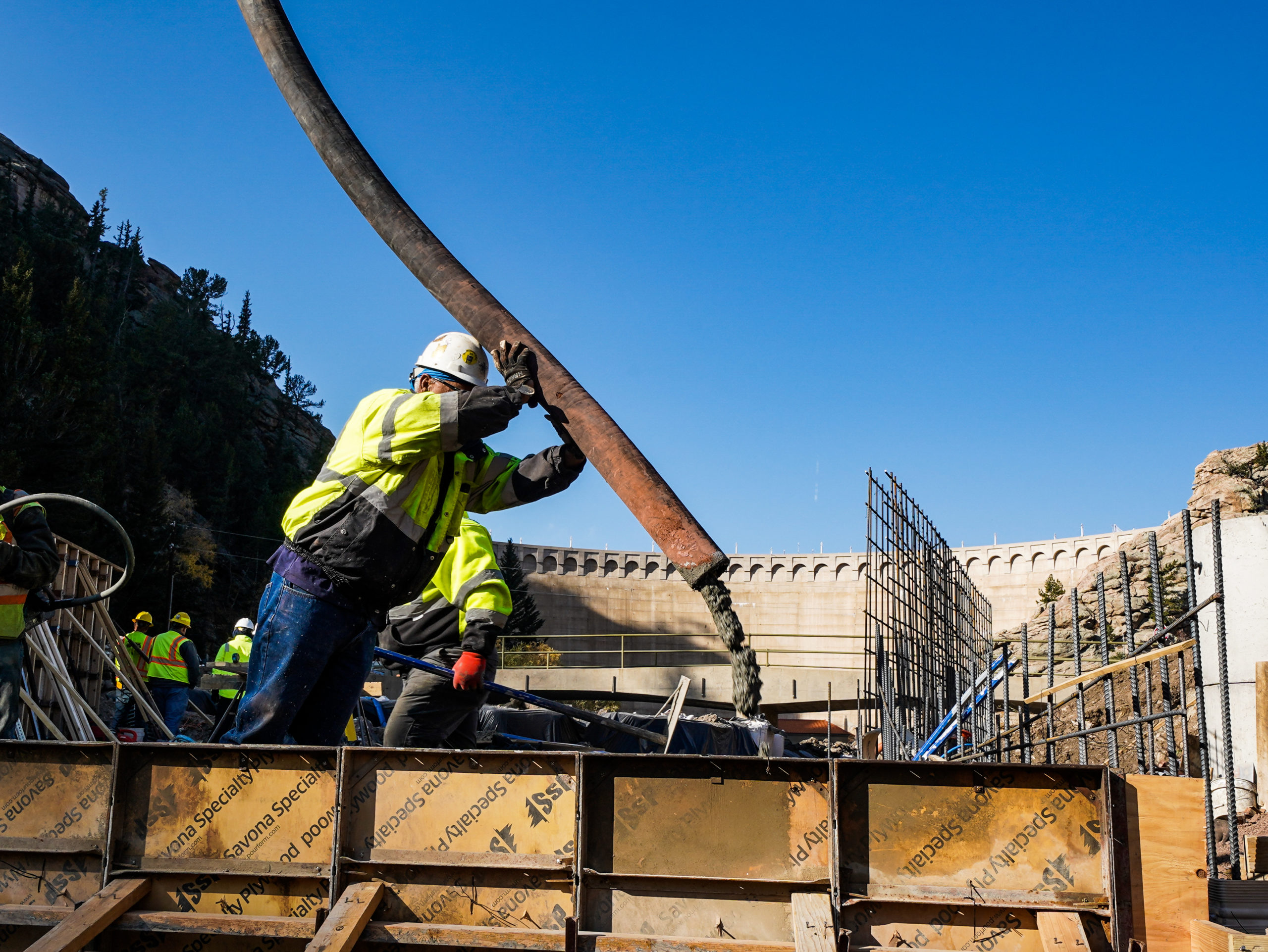 A construction worker pours concrete to form the foundation of the new flume. Photo credit: Denver Water.