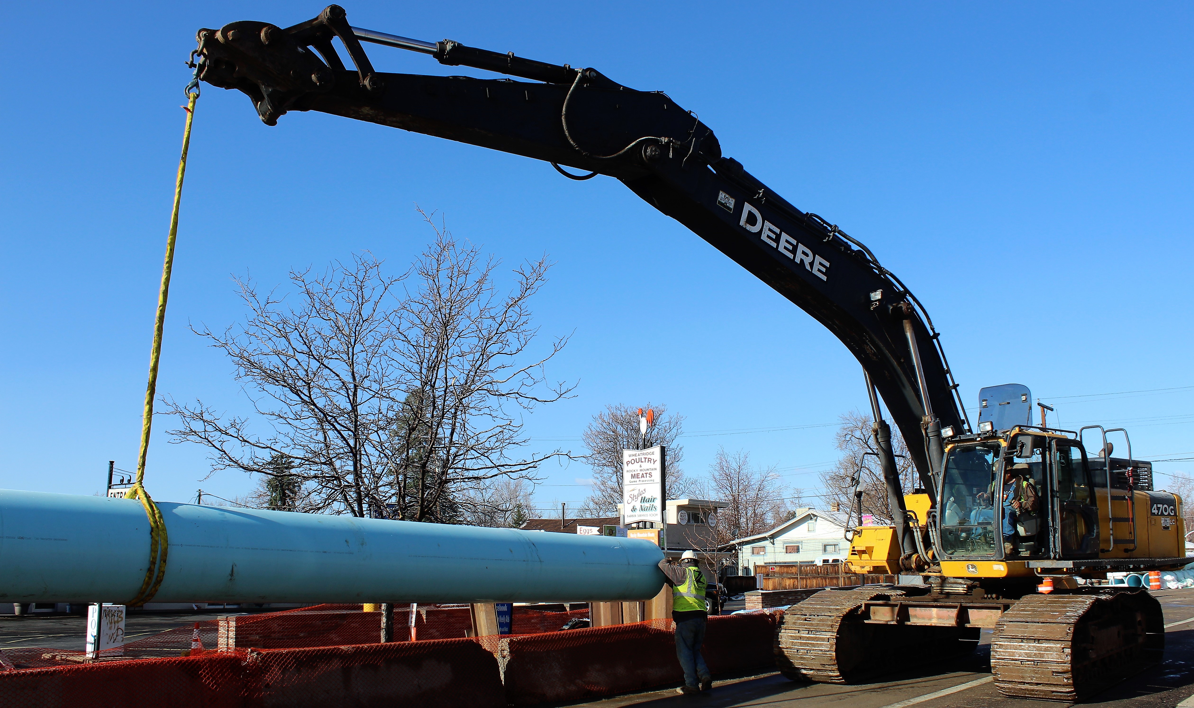 Crews lower a 40-foot pvc pipe into a small trench to begin installation on 29th Avenue as part of a pipe rehabilitation project. 
