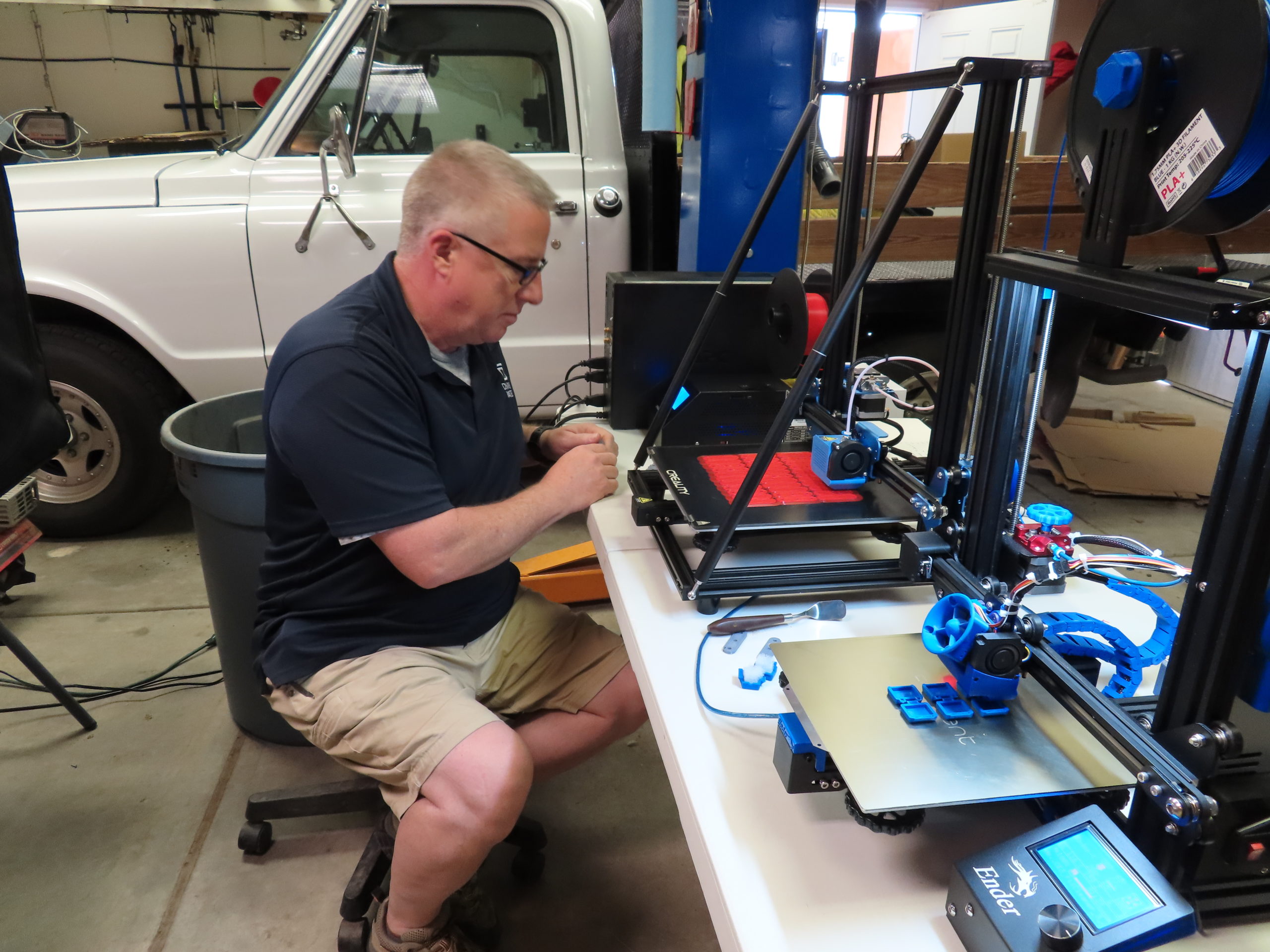 Mark Thomas, IT manager at Denver Water, uses a 3D printer to make plastic clips used to assemble homemade masks. Photo credit: Denver Water.