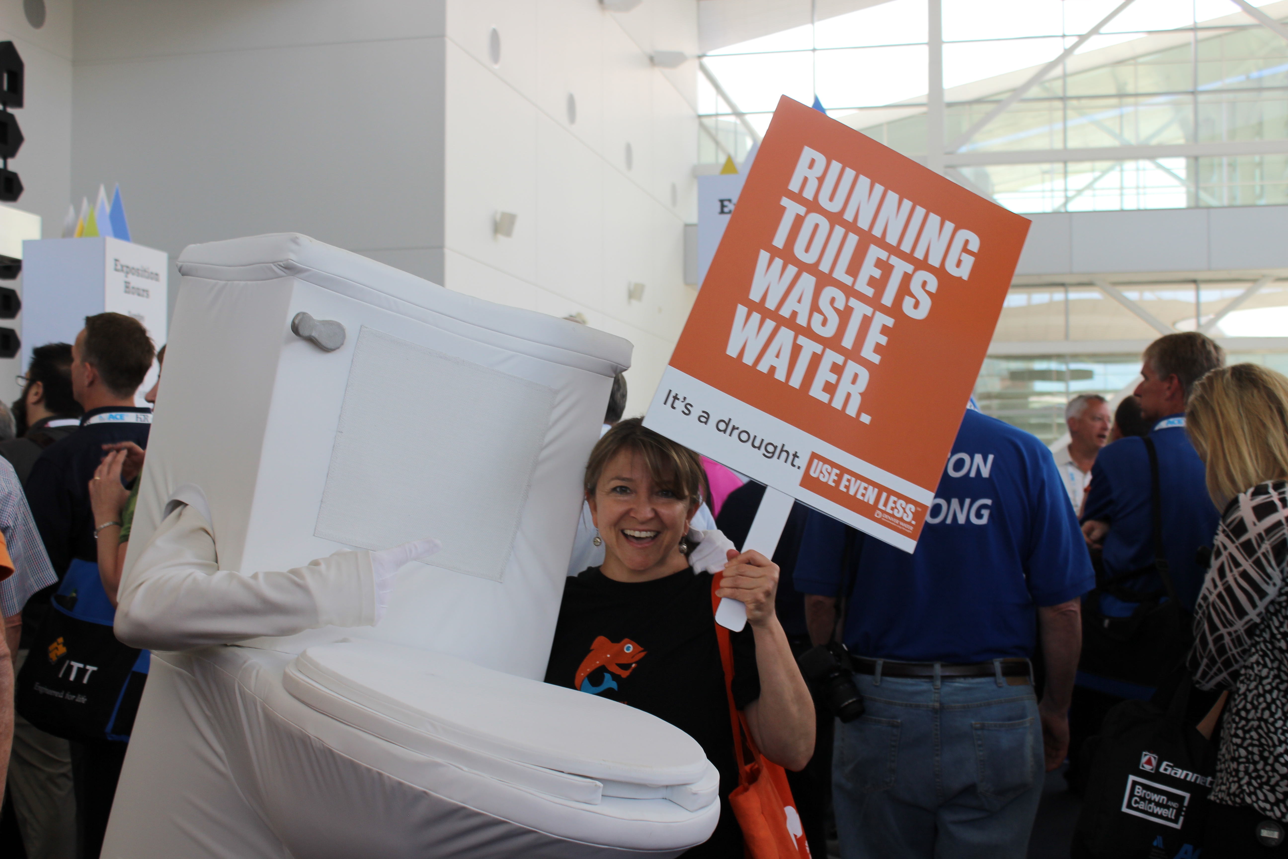Image of Denver Water's running toilet and a sign that says running toilets waste water.