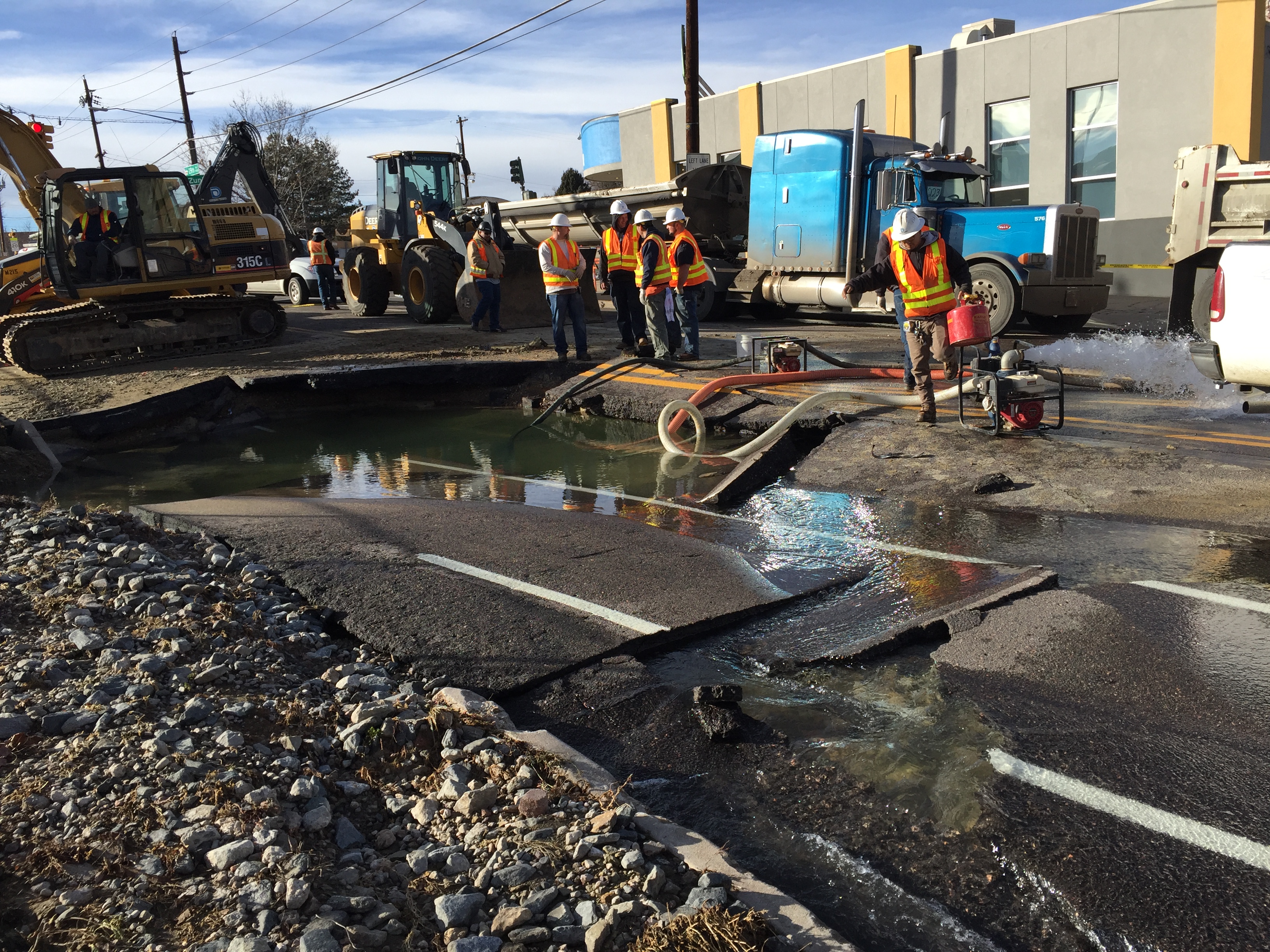 Crew draining water from hole after main break.