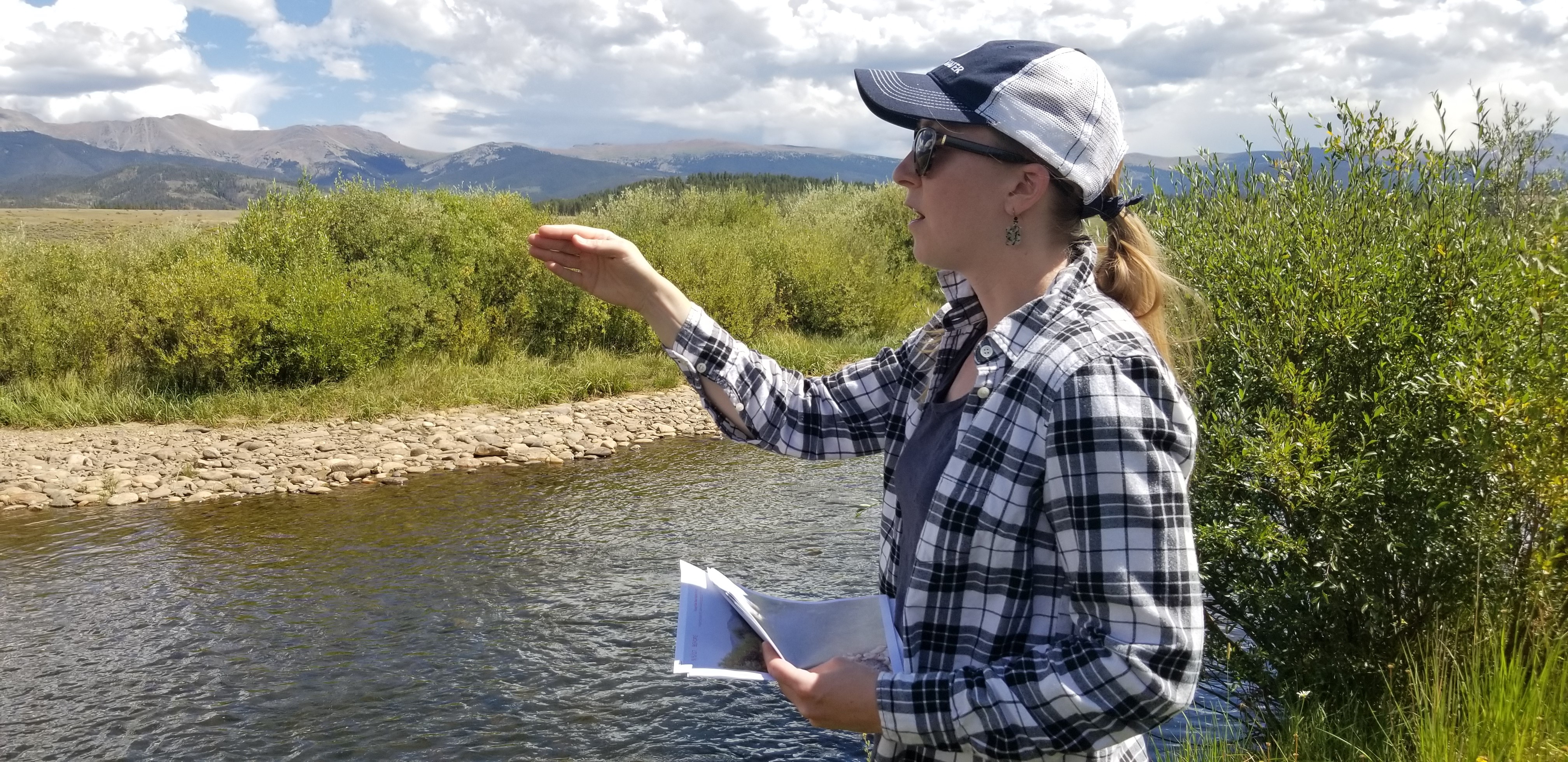 Denver Water lead environmental scientist Jessica Alexander points out improvements to the Fraser River following work in the Fraser Flats section of the river. Rock cobble on the opposite bank helps stabilize and narrow the channel, creating deeper water at low flows.