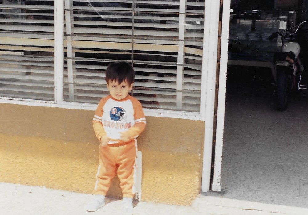 5.	Before his parents immigrated to the United States, Jose Salas’ father owned a convenience store in the Mexican state of Coahuila, which shares a border with Texas. Salas, pictured here in front of his father’s store in the late 1980s, was a Broncos fan at an early age. Photo credit: Jose Salas.