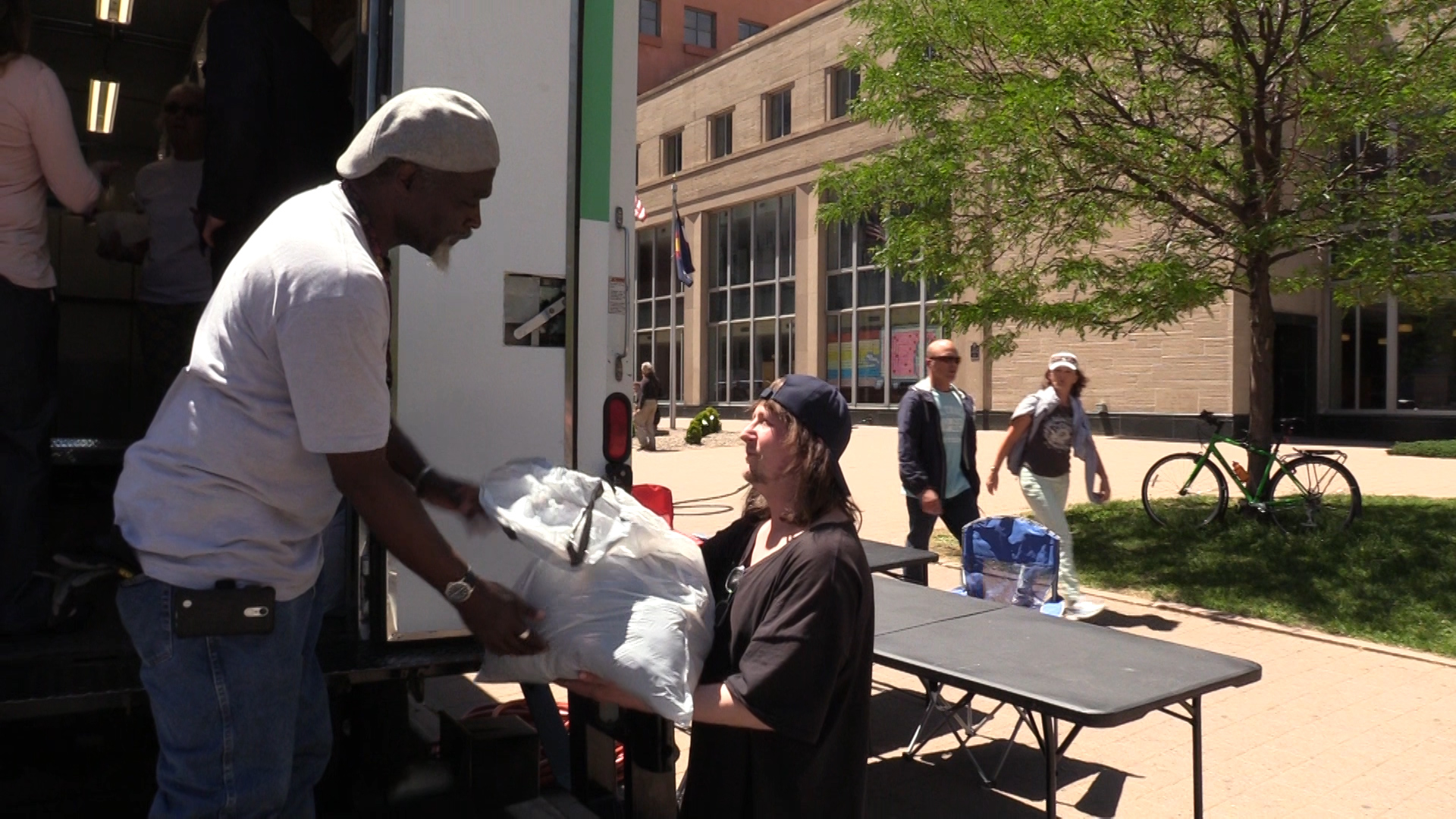 Marcus Harris, Laundry Truck coordinator, delivers a bag of clean clothes at the Denver Public Library downtown.