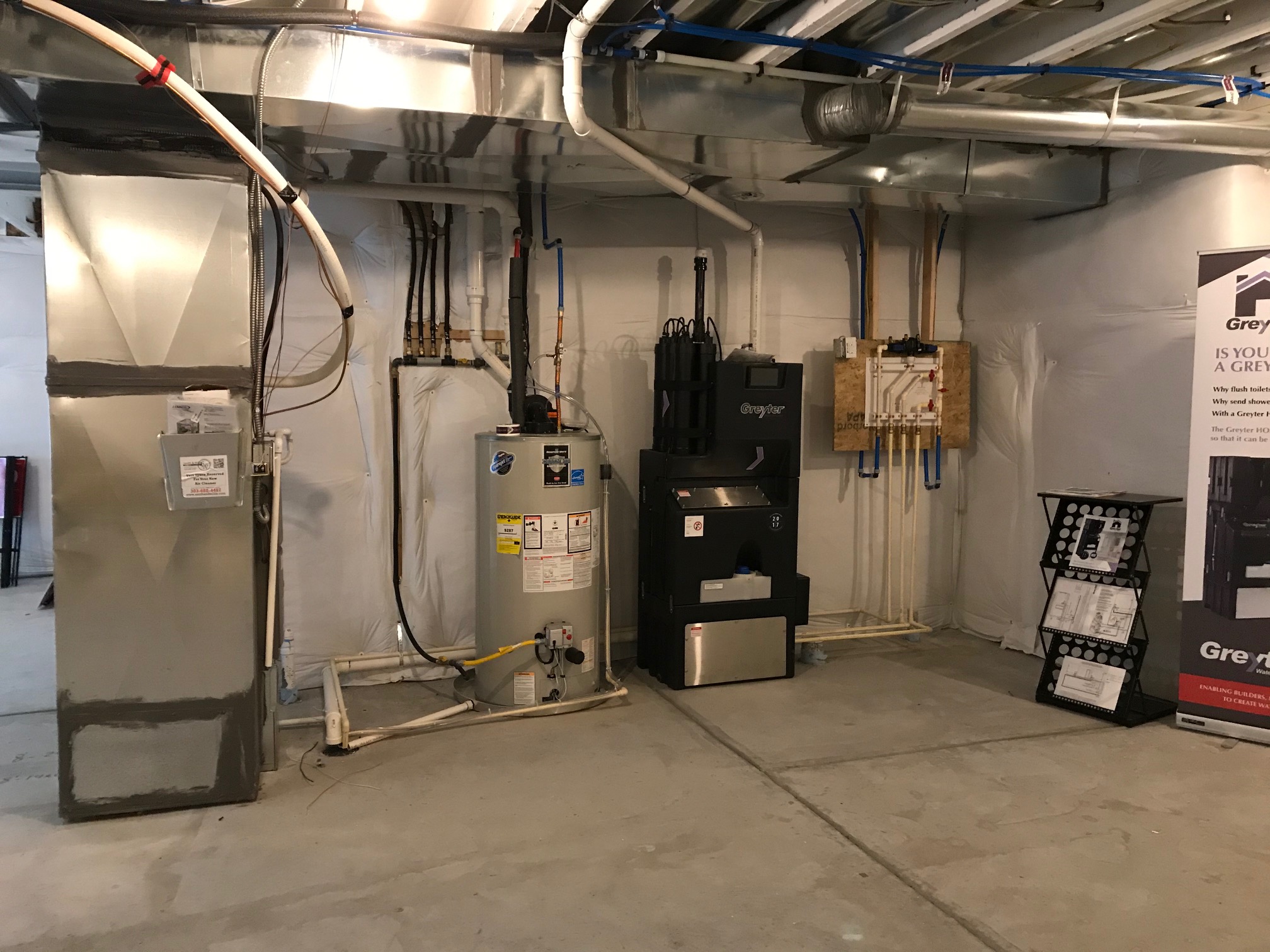 A greywater reuse system is shown in the basement of a model home.
