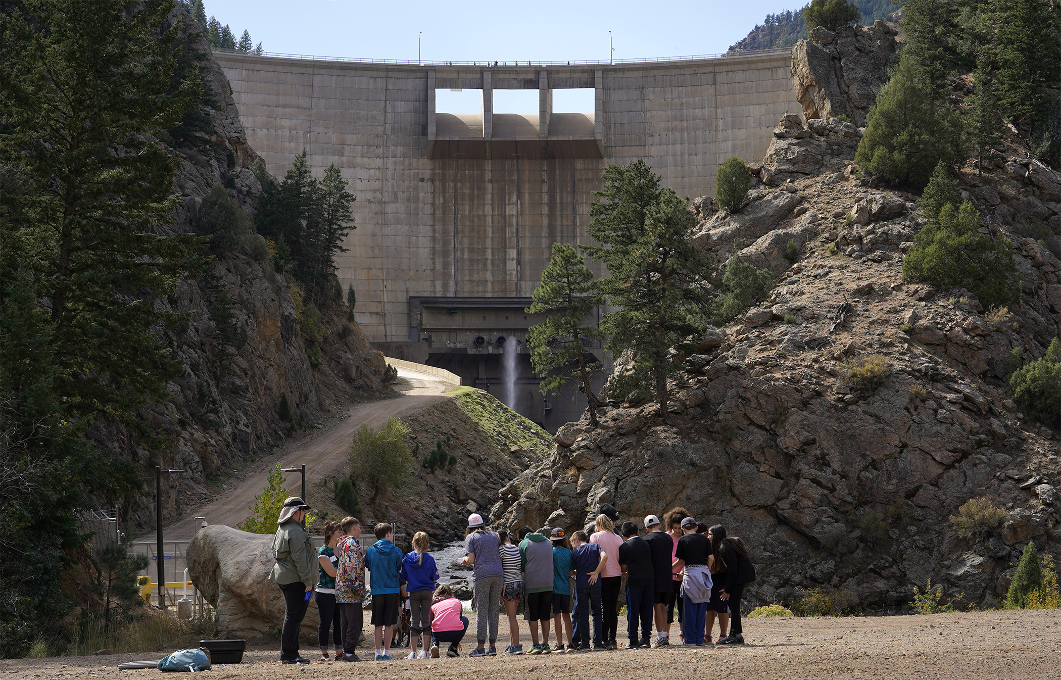 This photo shows students standing in front of a dam.