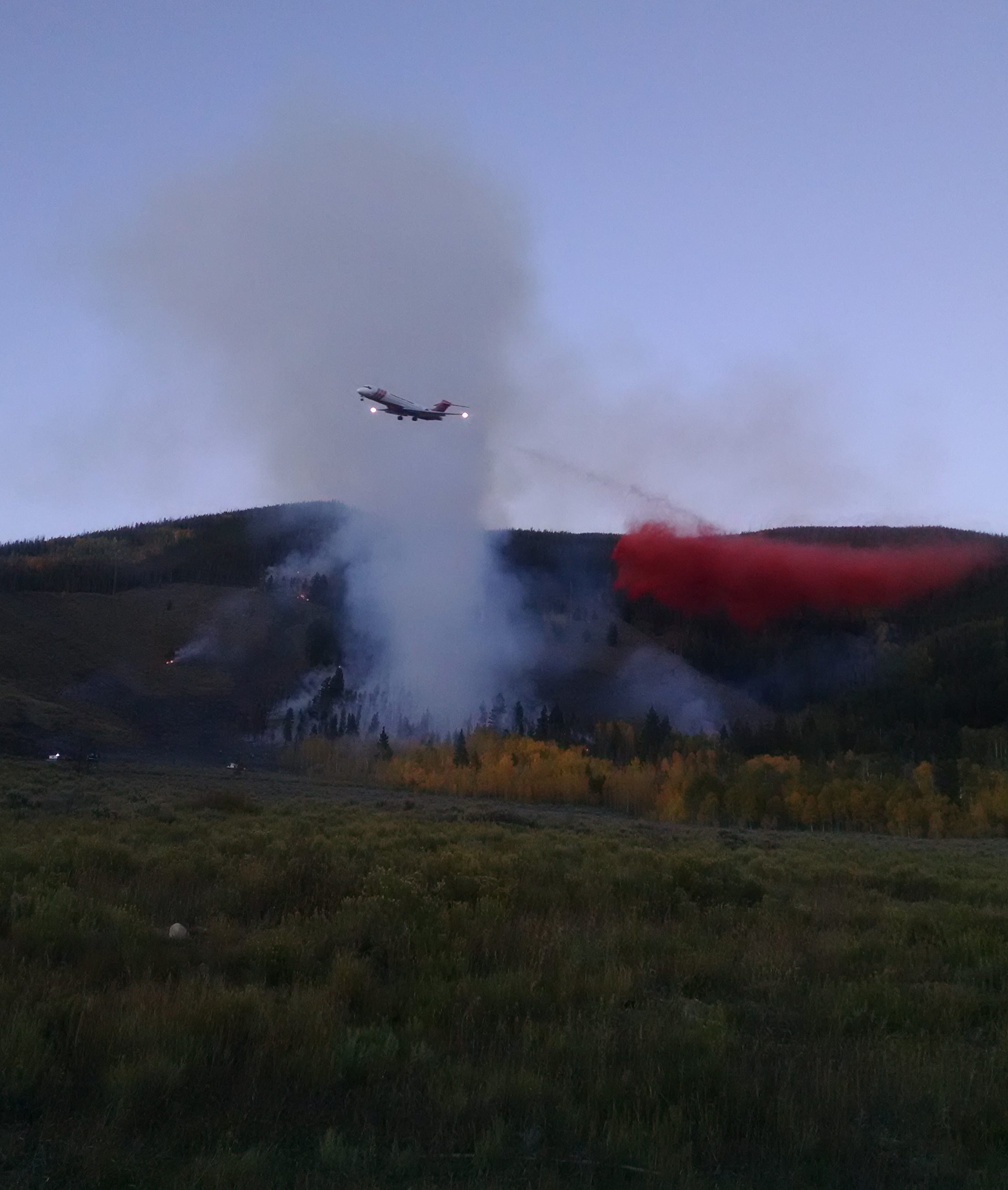 A slurry bomber drops fire retardant on the Tenderfoot 2 wildfire.